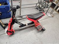 Photo showing right side view of Razor Drift Rider vehicle in red and black with seat, footrests, and front wheel.