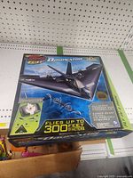 Box front showing Sky Pilot RC Dominator remote control airplane, points out full function controller, flies up to 300 feet (91 meters), no assembly required.