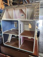 Full interior view showing three levels with multiple rooms decorated in wallpaper and some wood plank flooring, staircase included.