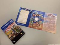 Overall set showing original box, booklet, and display with silver dollar and flag artwork