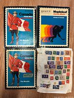 Front covers of three Scott Canada stamp albums: two with Mountie image, one with Mapleleaf hockey player illustration; one album open showing loose stamps on worn page.