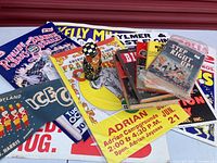 Various circus posters, books, and memorabilia displayed together on a surface creating a colorful collage. Contains promotional materials from Ringling Bros., Kelly Miller Circus, and other circus shows.