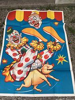 Large colorful poster laid out flat showing two clowns juggling pins and riding a dog, bright red, yellow, blue colors