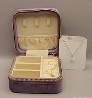 Opened purple velvet box showing adjustable compartments and necklace on display card