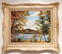 Front view of the framed oil painting showing autumn lake landscape.
