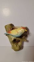 Front view of ceramic bird in nest wall pocket figurine showing the bird perched on a branch.