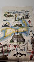 Full view of linen tea towel showing Cape Cod map with landmarks, sea creatures, and Cape Cod text
