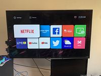 Front view of the 50-inch Proscan Smart TV powered on showing the smart TV apps interface including Netflix, Prime Video, Facebook, YouTube, and others.