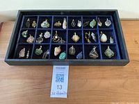 Full tray overview showing 32 wire-wrapped gemstone pendants