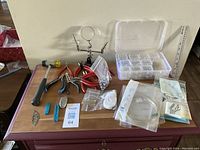 Full assortment of jewelry making tools and supplies laid out on wooden surface