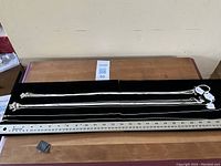 Photo showing multiple sterling silver chains laid out with a ruler for size reference, tagging visible with length.