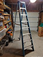 8-foot Werner A-frame stepladder standing open in a garage