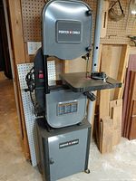 Front view of Porter-Cable floor-standing band saw showing housing, table, and base cabinet