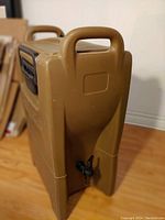 Front side view showing the spigot and two carry handles on the Carlisle container.