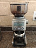 Front view showing the control buttons and hopper with coffee beans inside.