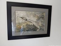 Framed Avro Arrow print hung on a plain white wall showing the entire frame and artwork.