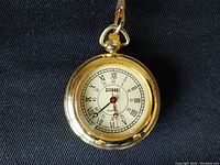 Front view of the Gitano gold-tone pocket watch showing the white face with Roman numerals and brand name.