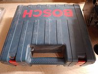 Closed Bosch branded blue plastic hard case housing the router and accessories.