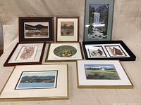 View of all eight framed artworks arranged together showing diversity of media and framing styles.