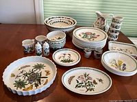Overhead view of entire set arranged on table showing plates, bowls, mugs, pitcher and accessories.