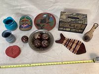 Full view of all decorative items including 3 vases, bowl with balls, face mask, plate, basket, trivet, and box