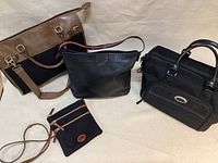 Four bags displayed: brown and black laptop bag, black leather Ann Taylor satchel, black leather handbag, small black crossbody bag.