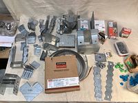 Overview of a variety of Simpson Strong-Tie metal connectors, fasteners, and rolls of cable strap, nails and vents.