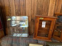 Two display cabinets shown together: wooden cabinet with glass door on right, glass and mirror cabinet to left.