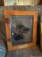 Framed stained glass artwork showing the German Shepherd head against a textured background inside a wooden frame with a metal plaque.
