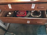 Drawer opened showing collection of boxed and loose assorted glass and metal dishes including the Waltherglass bowl and Bohemian Crystal dish.