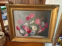 Full view of the framed floral painting showing pink, red, and white flowers in a blue and white vase with an ornate gold frame.