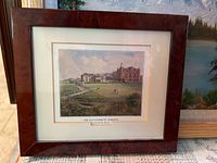 Framed print titled 'The Old Course St. Andrews' showing a historic golf course and buildings, with a brown wood frame and matte.