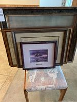 Four framed items stacked: two prints at front, two mirrors behind