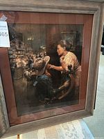 Framed painting "You Can Call Me Darlin" by Andy Thomas showing a cowboy and woman in close interaction. The painting is framed with reddish matting and a rustic wood frame.