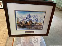 Framed print showing mountain and water landscape by Joanne Hennes, titled and measured