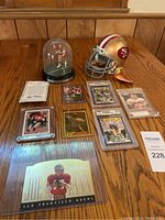 Group shot of all items on table: helmet, dome display, COA and various cards