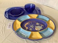 Clear blue acrylic oval tray with 4 plates and 4 bowls. Porcelain colorful fish design compartment tray.