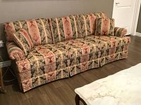 Wide view of the Lawson style sofa showing overall symmetrical Regency fabric upholstery with rolled arms and skirted bottom.