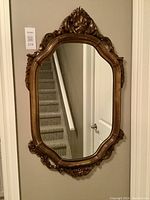 Full view of the framed mirror showing the entire shape, size, and reflective surface.