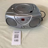 Front view of silver Sylvania portable CD player with two speakers, digital display and CD top loader.