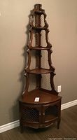 Photo of entire dark solid wood tiered corner hutch, showing shelves, lattice panels, and bottom two-door cabinet.