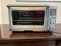 Front view of stainless steel toaster oven showing glass door and control panel