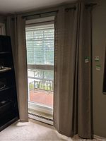 Curtain panels hung on metal rod in front of a window.