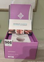 Open purple doTERRA AromaTouch Diffuser Enrollment Kit box with instructional booklets and box for Petal Diffuser inside.