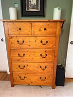 Front view of pine wood veneer dresser showing two smaller top drawers with round knobs and four larger drawers with metal pull handles.