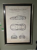 Framed patent print showing four different views of an Aston Martin vehicle, side, top, front, and rear views.