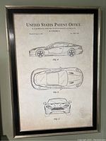 Full view of the framed patent print showing three technical illustrations of the Aston Martin car and text from the US Patent Office.