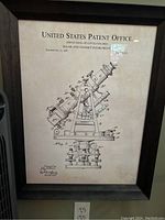 Framed patent print showing entire instrument drawing and frame with visible electrical outlet below