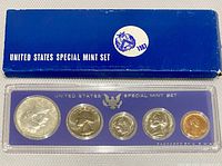 Front view of the 1967 United States Special Mint Set in original plastic casing with blue insert and original blue box. Coins visible: half dollar, quarter, dime, nickel, and penny.