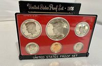Front view of the 1976 US Bicentennial Proof coin set case showing six coins including $1, half dollar, quarter, dime, nickel, and penny coins in plastic casing with red insert.